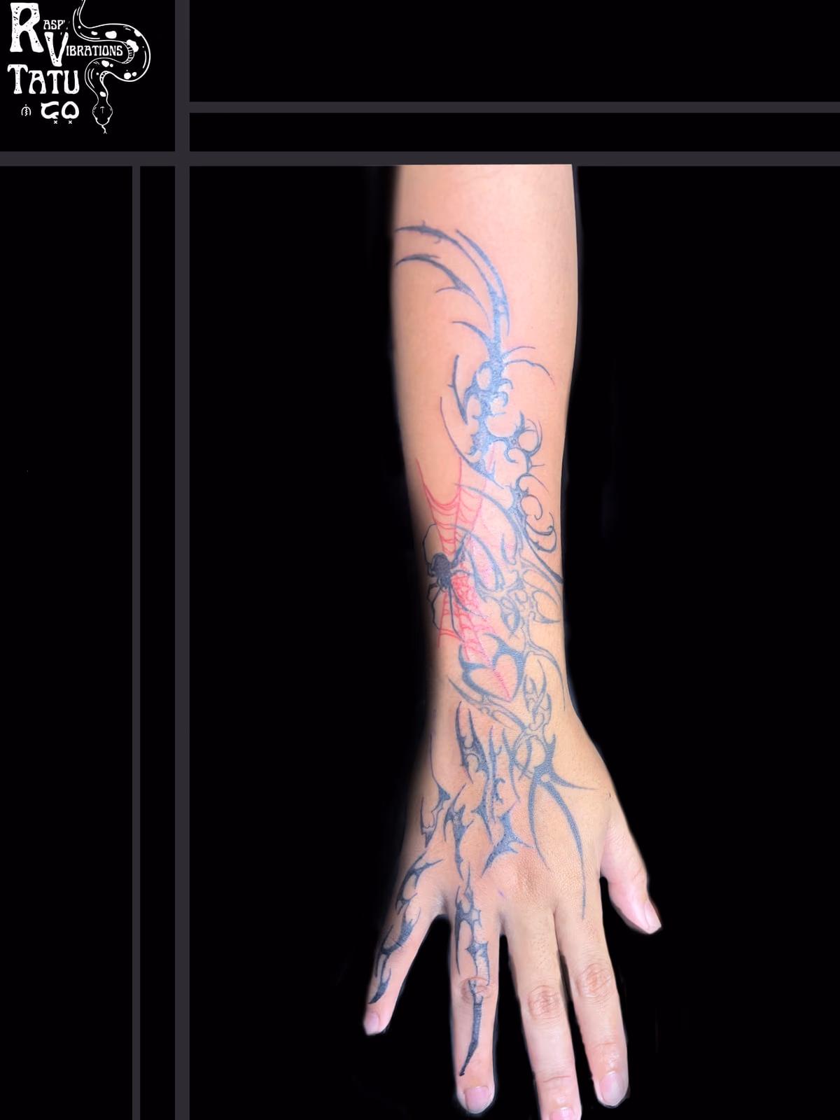 Freshly tattooed arm and hand with flowing tribal linework, the skin still reddened from the session.
